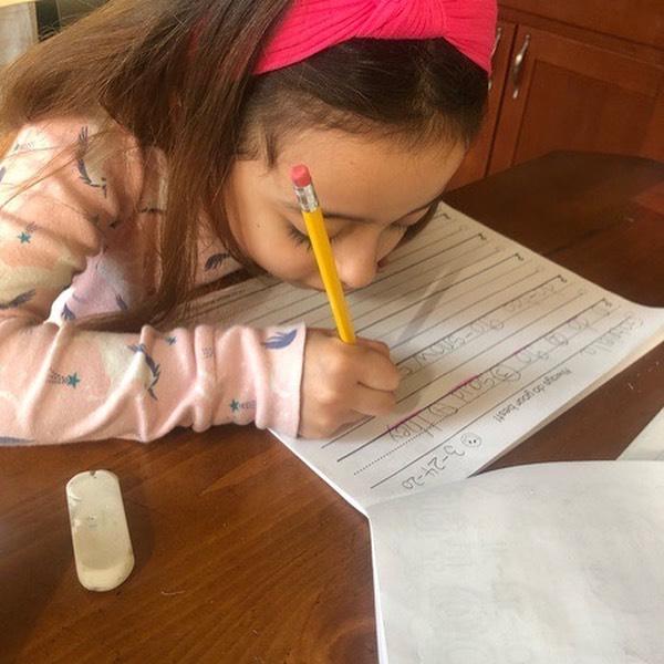girl doing her writing activity in the kitchen